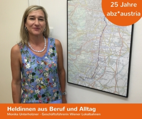 Monika Unterholzner lächelt in die Kamera. Sie steht vor einer Landkarte mit der Linienführung der Badner Bahn