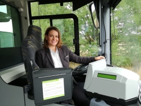 Renate Lehninger sitzt am Lenkrad eines Busses. Sie lächelt stolz in die Kamera.