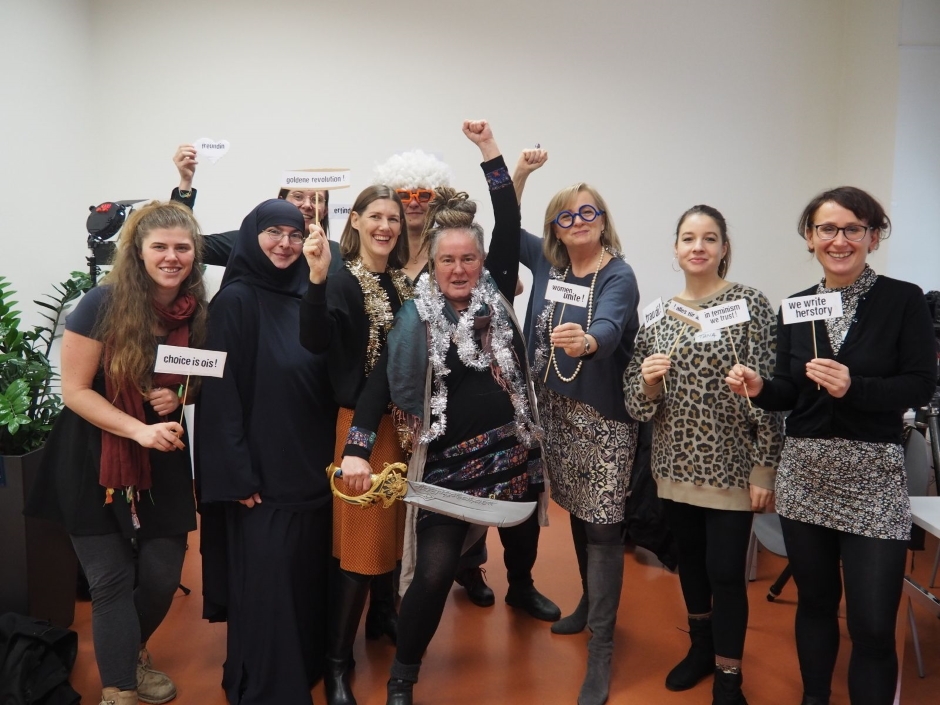 Lustiges Foto, die Teilnehmerinnen halten Schilder in die Kamera, mit Texten wie "goldene revolution" oder "women unite!"