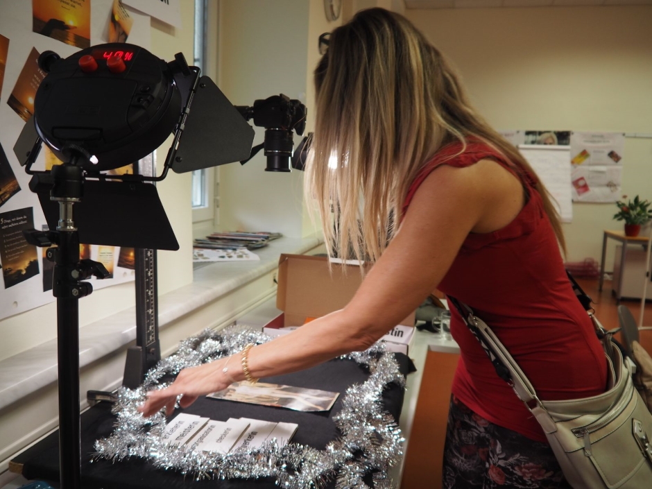 Bei der "Audio Station" sollten Fragen wie "Was ist Feminismus? Ist Feminismus notwendig? Wo fühlst du dich im täglichen Leben eingeschränkt? als Inspiration dienen. Eine Frau mit rotem Oberteil legt Schilder zum Fotografieren auf einen Tisch