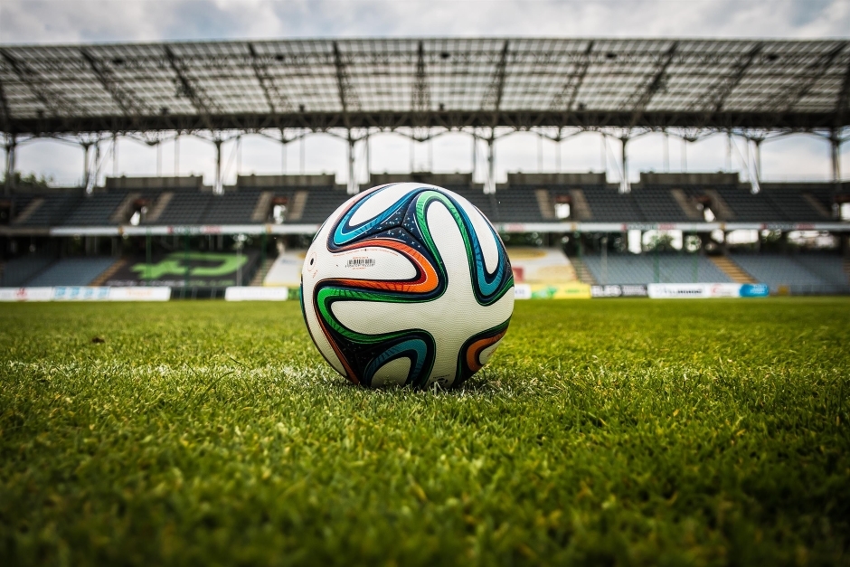 Ein Fußball steht auf dem Rasen in einem Fußballstadion.