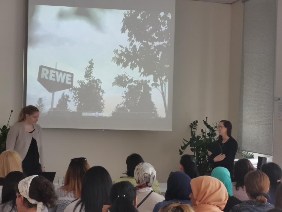 Karrieremöglichkeiten: "Wenn die Führungskraft zufrieden ist und Sie jetzt schon Erfahrung mitbringen und sich beweisen, dann kann das sehr schnell gehen, hängt aber natürlich auch davon ab, wie schnell und wo eine Stelle frei wird." Das Publikum schaut interessiert ein Video der REWE-Group an