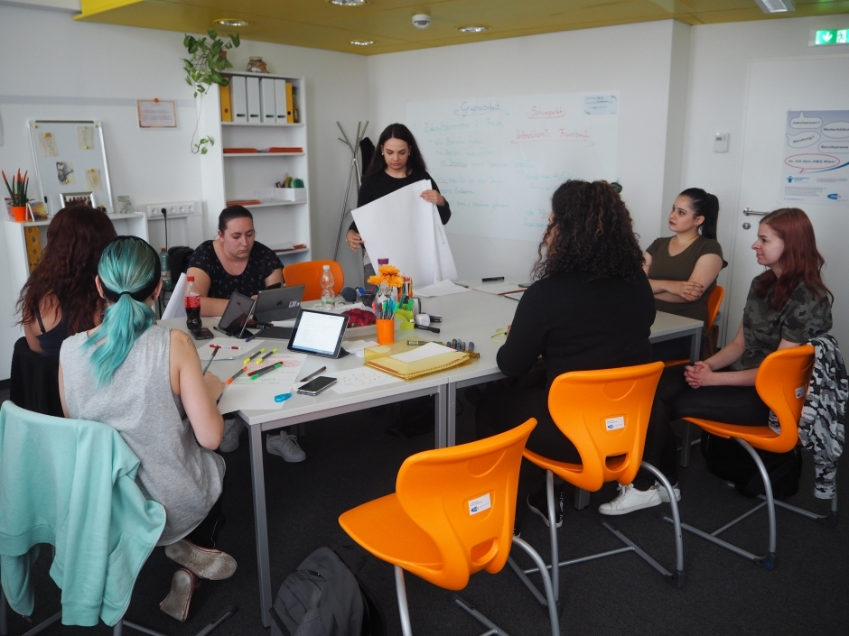 Die #futurefactory ist ein Projekt, in dem Frauen Zeit haben über ihre berufliche Zukunft nachzudenken. Eine Gruppe von Frauen arbeitet an einem Tisch. Vor ihnen liegen Stifte, Papier und Ipads.