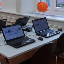 Tisch mit vier aufgeklappten Laptops